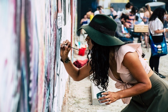 woman is painting a wall by paints